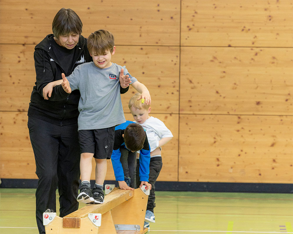 Trainerin der LG Fulda beim Balancetraining mit Kindern auf einer Bank