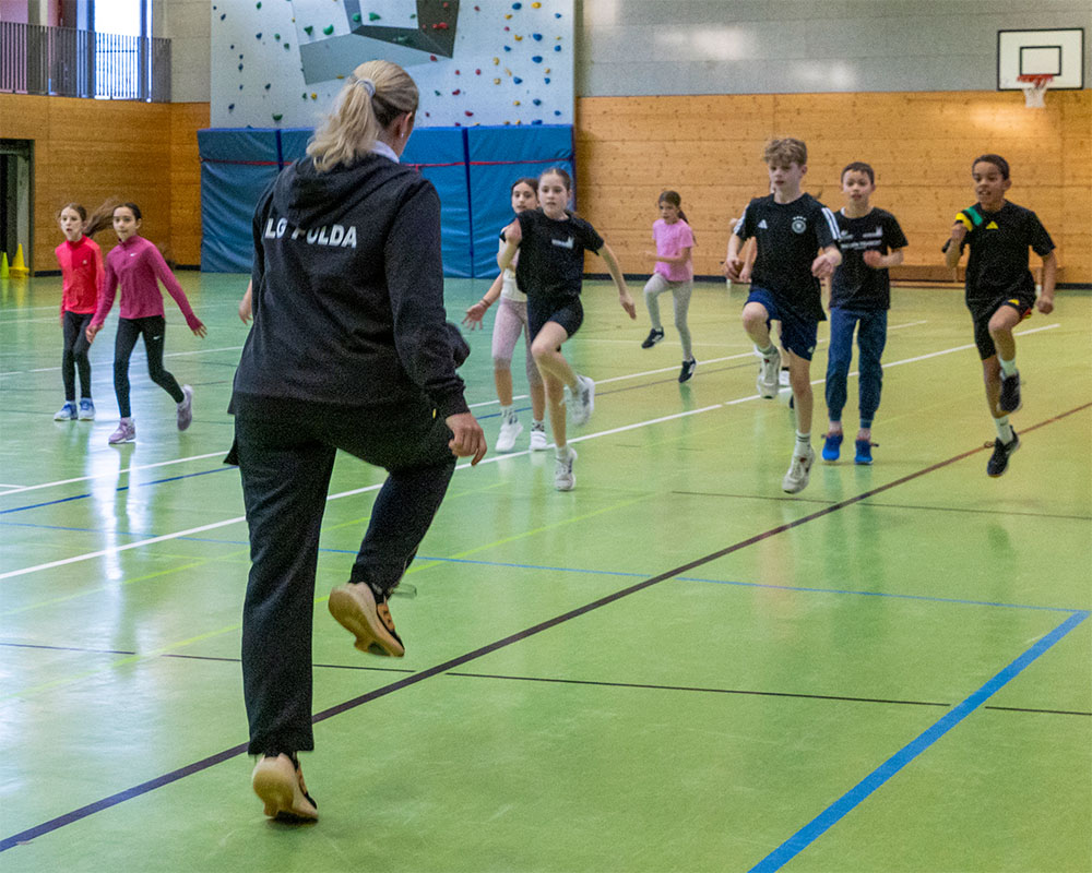 Trainerin mit Kindern beim Training in der Halle