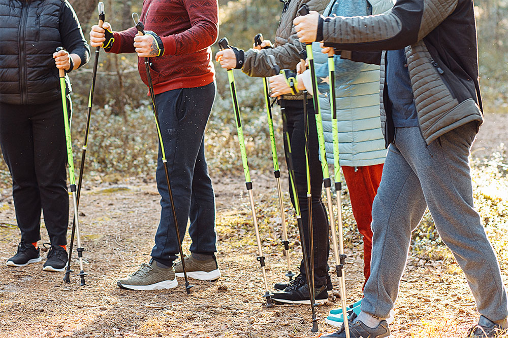 Eine Trainerin zeigt der Gruppe die Technik für Nordic-Walking
