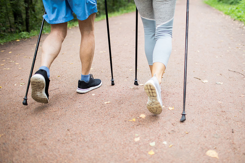 Zwei Nordic Walker auf einem Gehweg